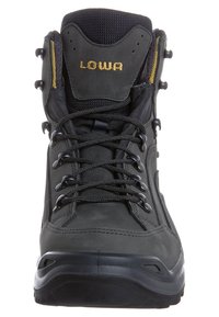 Scarponcino da trekking alto nero con lacci neri, occhielli in metallo, collo imbottito e logo "LOWA" in oro sulla linguetta.