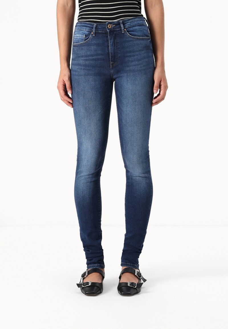 Tanke jeans v temno modrem denimu z gladko teksturo, z srednje visokim pasom, sprednjimi žepi in zapiranjem na en gumb.