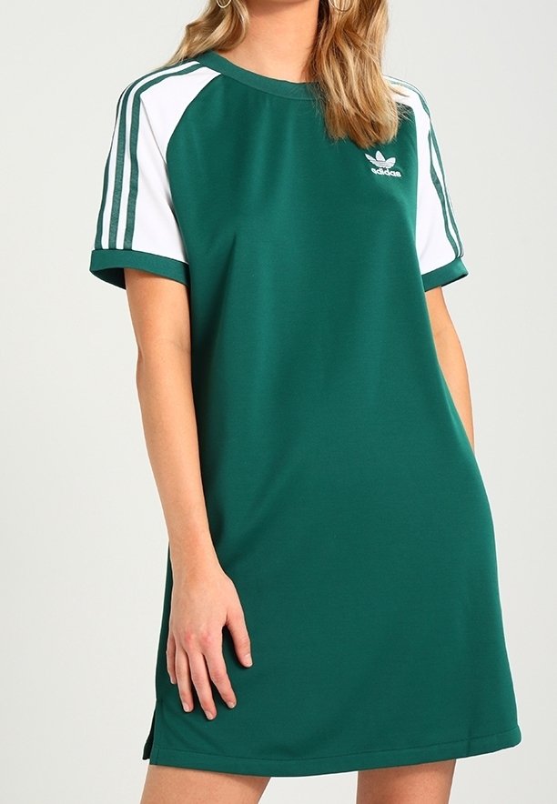 Robe de sport verte avec manches courtes blanches et trois bandes blanches sur les épaules. Présente un col rond et un petit logo sur la poitrine.