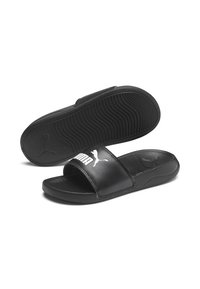 Black synthetic slide sandals with a wide strap featuring a white Puma logo, textured footbed, and a rubber outsole with a wave pattern.
