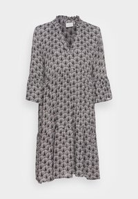 Robe à motif noir et blanc avec un col froncé, des manches longues et un design en niveaux comportant un motif d'éventail sur l'ensemble.