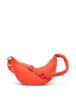 Sac bandoulière en forme de croissant de couleur orange vif avec une sangle ajustable et une poignée rembourrée, arborant un petit logo sur le devant.