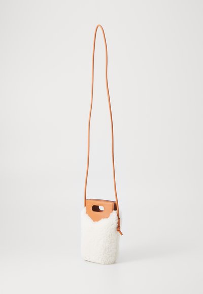 Crossbody taske med en hvid struktureret pelskrop og en glat orange lædertop. Har et udskåret håndtag og en lang justerbar rem.