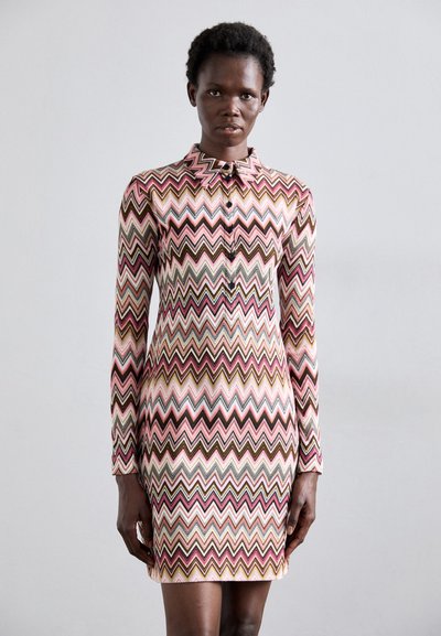 Huben dress s dlouhými rukávy; cik-cak vzor v růžové, béžové, hnědé a tyrkysové; zapínání na knoflíky u límce; těsně přiléhající střih; hladká textilie.