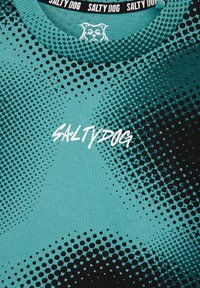 Turkio spalvos marškinėliai su gradientiniu taškų raštu, kuris pereina nuo juodos iki turkio. Apskritai krūtinėje balta script’o stiliaus užrašas "SALTY DOG".
