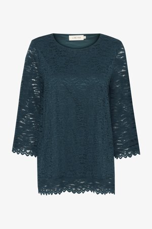 Teal lace toppi, jossa on kolmannen osan hihat, pyöreä pääntie ja reunassa viilto. Koristeena kukkakuosi ja puoliläpinäkyvä rakenne. Merkki: Cream.