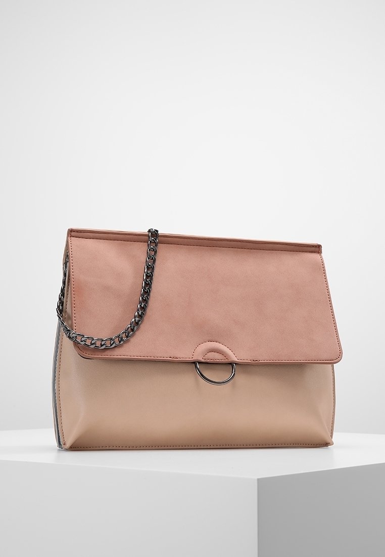 Růžová a béžová kožená kabelka s řetízkovým popruhem, magnetickým uzávěrem a kulatým akcentem na přední straně. Hladký povrch s pevným tvarem.