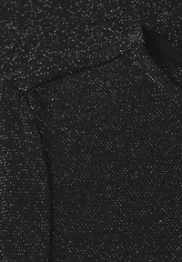 Zwarte gebreide stof met zilveren glitters, met een zachte textuur en een gladde afwerking. Bevat een subtiele glans.