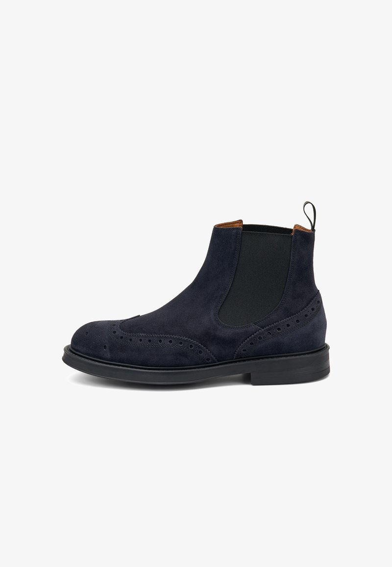 Stivaletti Chelsea in camoscio blu navy con pannelli elastici laterali, dettagli brogue, punta rotonda e suola in gomma nera; linguetta sul retro per una facile calzata.