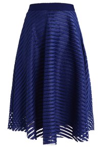 Marinblå kjol gjord av lager av randig meshtyg. Har ett fast midjeband och en A-linjeformad silhuett med en fåll som vidgar ut sig.