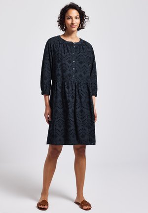 Robe en coton bleu foncé, brodée, avec un col rond, des manches trois quarts et une jupe évasée, arborant des boutons sur le devant.