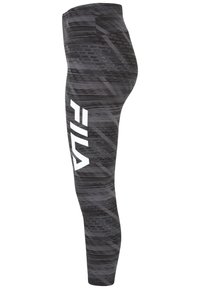 Leggings a fantasia nera e grigia con un design aderente. Presentano un grande logo bianco "FILA" sul lato sinistro. Texture liscia.
