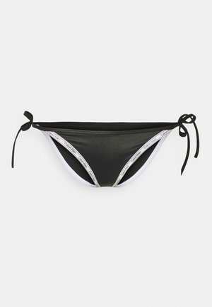 Crne bikini gaćice s podesivim vezicama sa strane, sa kontrastnim bijelim pojasom s "Calvin Klein" brendom. Glatka tekstura.