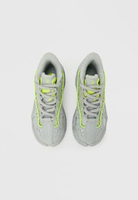 Γκρι αθλητικά παπούτσια με νέον πράσινες λεπτομέρειες, πλέγμα και υφασμάτινες επιφάνειες, σχέδιο με κορδόνια και μαξιλαρωτό γιακά.