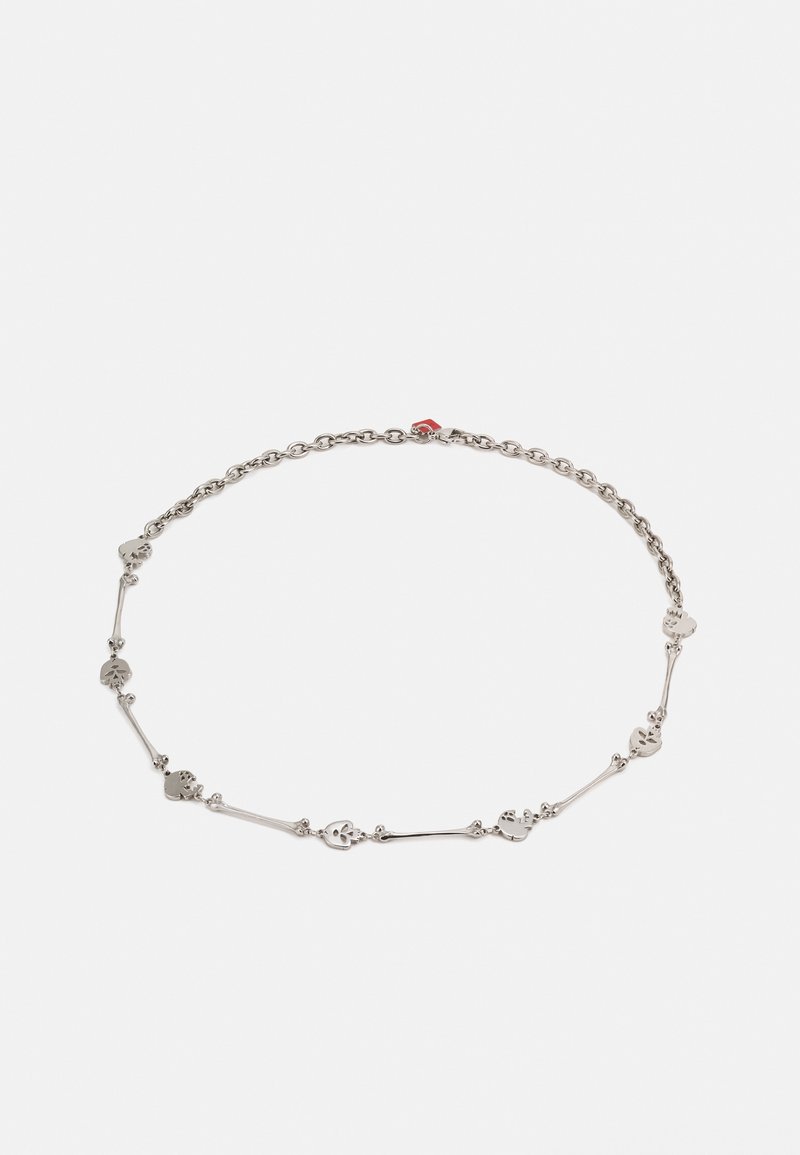Collier chaîne fine en argent avec des maillons alternés en forme de petits crânes et d'os sur un fond blanc uni.