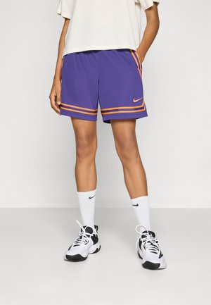 Lilla idrettsshorts med oransje striper, med et Nike-logo. Kombinert med hvite sokker og svart-hvite joggesko for et sporty utseende.