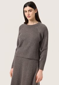 Gray ribbed knit sweater with a crew neckline and fitted design; features long sleeves and a slightly cropped hem for a modern look.