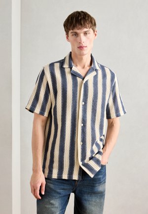 Kortærmet skjorte med knapper i skiftende blå og beige striber med et struktureret mønster. Stoffet ser let og åndbart ud.