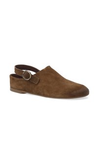 Brun ruskind slingback sko med rund tå, flad sål og justerbar rem med en cirkulær metalaccent.