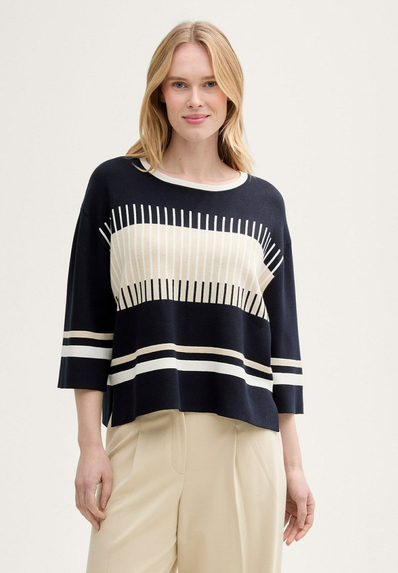 Pull en tricot navy à manches courtes, orné de rayures horizontales crème et beige, texturé de lignes verticales et doté d'un large col rond.