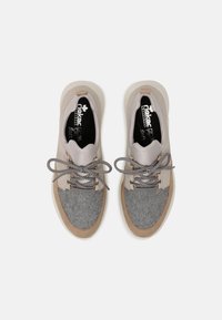 Grey and beige sneakers with a textured felt toe, smooth leather upper, round laces, and a rubber sole. Branding visible on the insoles.