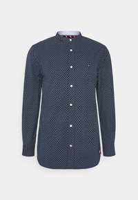 Camicia a maniche lunghe di un blu scuro con un piccolo motivo geometrico, chiusura a bottoni, collare a fascia e un colletto interno a righe di contrasto.