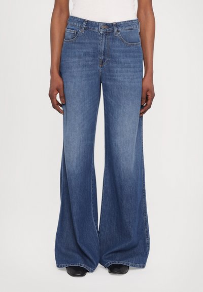 Jeans o szerokich nogawkach wykonane z niebieskiego denimu, z wysokim stanem, subtelnymi detalami przeszycia i przednimi kieszeniami. Gładka tekstura i długość do podłogi.