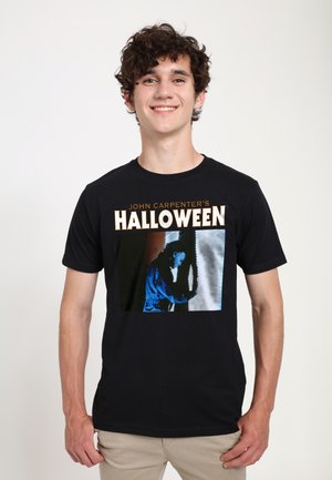 Černé bavlněné tričko s grafickou potiskem "Halloween" od Johna Carpentera, zobrazující postavu v modrých tónech. Design s krátkým rukávem.
