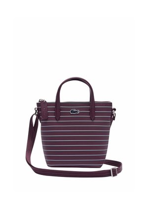 Petit sac à main marron foncé avec des rayures horizontales blanches, doubles poignées, bandoulière ajustable et un petit logo crocodile à l'avant.