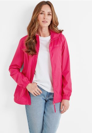 Bright pink lightweight jacket with elastic cuffs, a zippered front pocket, and a logo on the chest, paired with a white shirt and blue jeans.