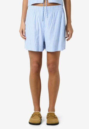 Blue and white striped shorts with an elastic waistband, featuring a relaxed fit and a smooth texture. The model wears brown slippers.