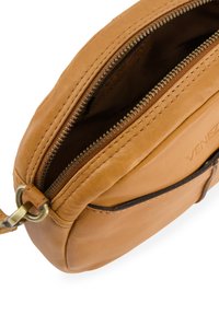 Brązowa skórzana torba na ramię częściowo rozpięta, pokazująca metalowy zamek błyskawiczny oraz wytłoczoną nazwę marki "Venezia" z przodu.