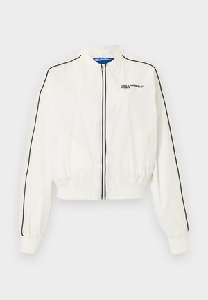 White zip-up bomber jacket with black piping along sleeves and front zipper, featuring "Karl Lagerfeld Jeans" logo on left chest.