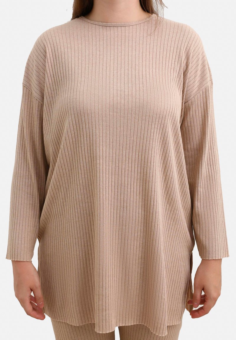 Beige ribbet langærmet top med rund halsudskæring, afslappet pasform og sidelæg. Har et blødt, tekstureret stof og en løs design.