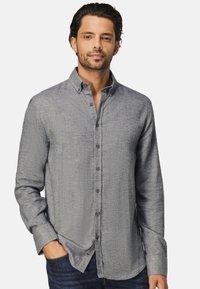 Lange mouw knoop-up shirt van lichtgrijze stof met een textuurpatroon, voorzien van een kraag en donkere knopen, gecombineerd met blauwe denim jeans.