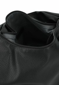 Sac en cuir noir avec une finition texturée. La fermeture à glissière supérieure révèle un intérieur spacieux doublé d'un tissu lisse.