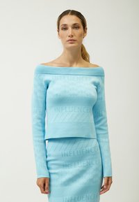 Top azzurro chiaro lavorato a maglia con design off-shoulder e motivo testurizzato "INFLUENCER", abbinato a una gonna aderente coordinata, con maniche lunghe e un taglio cropped.