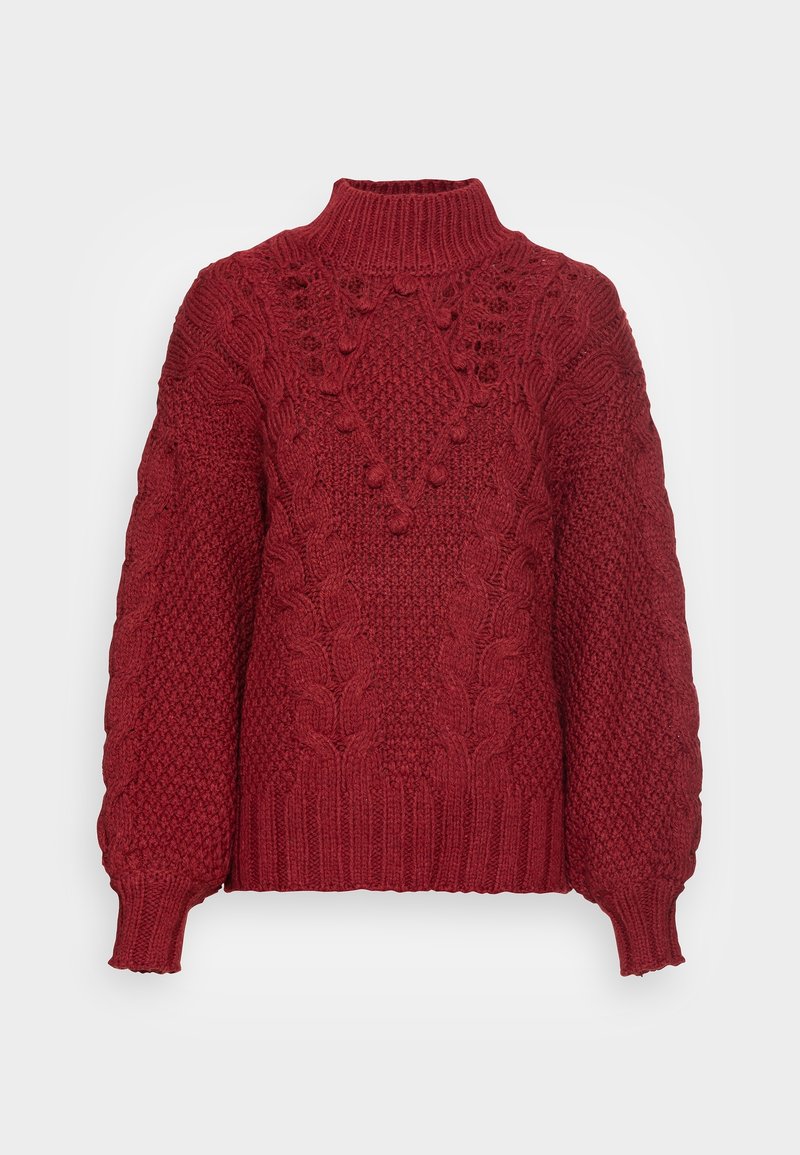 Maglione rosso lavorato a maglia con collo alto, motivi a treccia e dettagli testurizzati. Le maniche a sbuffo e l'orlo a coste aggiungono dimensione.