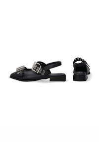 Czarne buty slingback z wydłużonym noskiem, z metalowymi detalami i wieloma oczkami na szerokich paskach dla regulacji. Niski obcas w kształcie bloku.