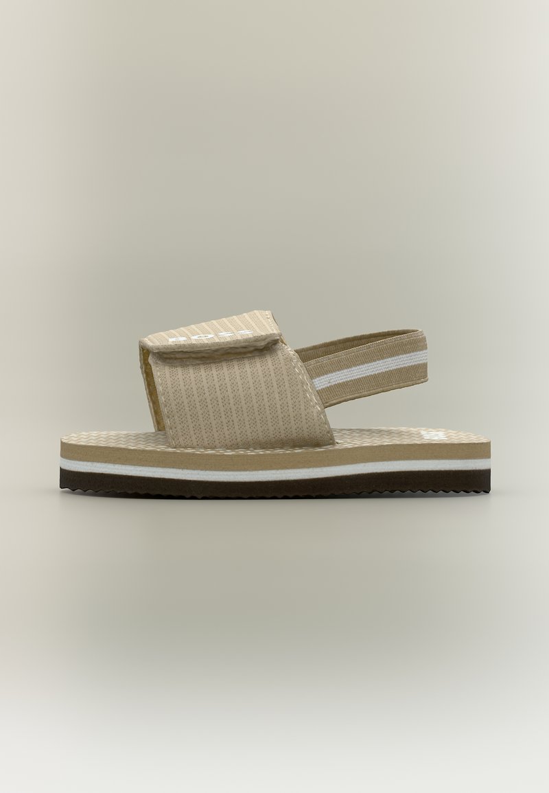 Smėlio spalvos atviri sandalai su storu padu, reguliuojama Velcro spaude virš pėdos ir elastine juosta gale su baltais dryžiais.