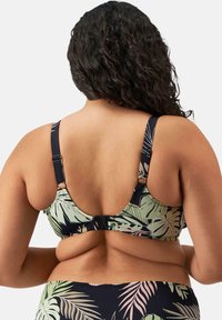 Zwart-groene tropische print bh met dikke bandjes en verstelbare hardware. Glad materiaal met een lage rugontwerp en bladbebloeiing.