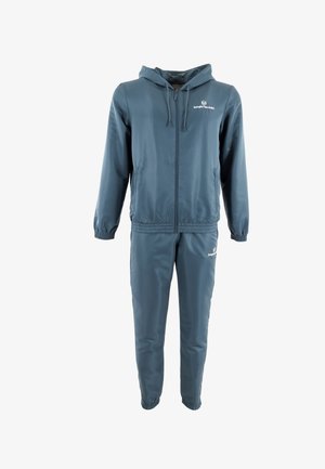 Survêtement de couleur bleu sarcelle, fabriqué en tissu lisse. Comprend une veste à capuche zippée et un pantalon avec taille élastique, tous deux dotés d'accents de logo.