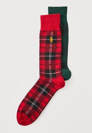 Deux paires de chaussettes à carreaux, une rouge et noire avec un logo jaune et une vert foncé et noire, présentées à plat sur fond blanc.