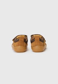 Brown suede and mesh shoes featuring a lightweight design, adjustable straps, and a rubber sole for grip. Brand name "froddo" embossed.