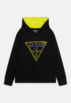 Sweat à capuche noir avec un logo triangulaire jaune affichant "GUESS U.S.A." et un point d'interrogation. Intérieur de la capuche vert néon. Poche kangourou à l'avant.