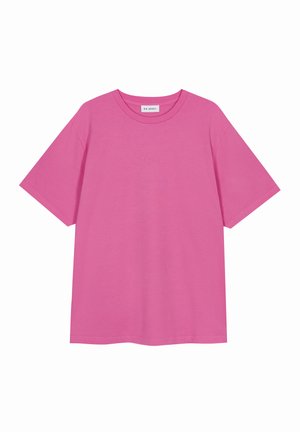 Camiseta de algodón rosa con mangas cortas, cuello redondo y corte relajado. Presenta un logo minimalista en la parte frontal. Textura suave y lisa.