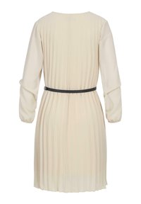 Robe plissée crème à manches longues et col rond, dotée d'une ceinture noire à la taille. Tissu doux et léger.