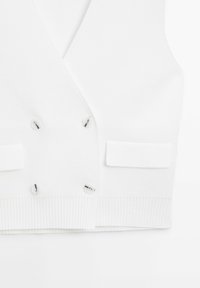 Biały dziergany kamizelka dwurzędowa z czterema guzikami, zakończona prążkowanym ściągaczem, z dwoma małymi przednimi kieszeniami.