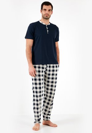 Mørkeblå bomulds t-shirt med ternet krave, parret med elfenbensfarvede og marineblå ternede pyjamasbukser, der har to sidelommer.