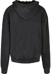 Sort hættetrøje lavet af tekstureret stof. Har en hætte med snoretræk, lange ærmer og ribbede manchetter og kant. Vist fra bagsiden.